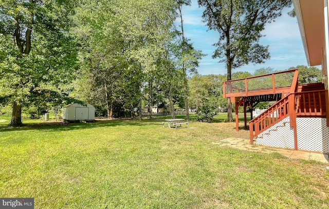 view of yard with a wooden deck and a storage unit