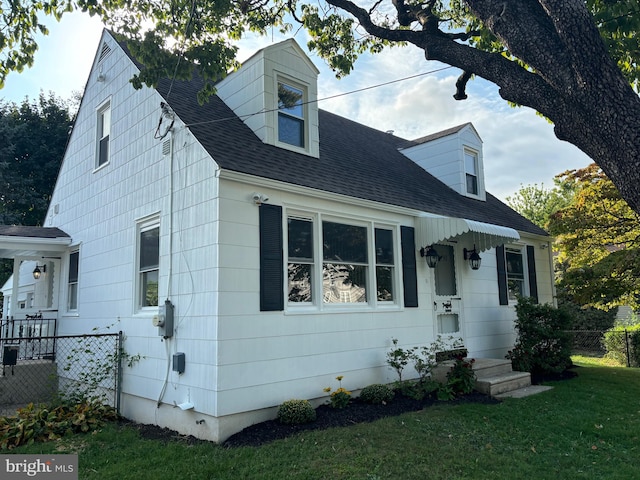 cape cod-style house with a front yard