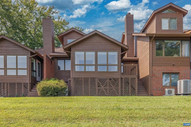 rear view of house featuring ac unit, a chimney, central AC unit, and a lawn