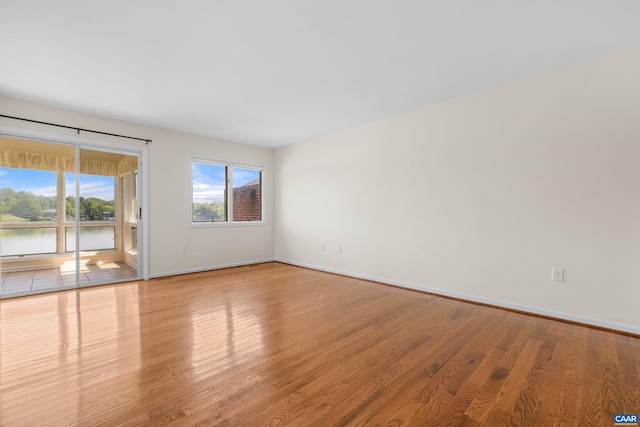 spare room featuring baseboards and wood finished floors