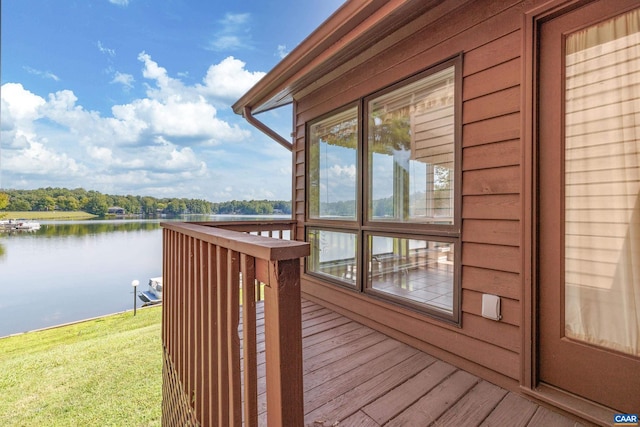 wooden deck with a water view and a yard