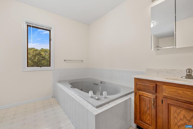 bathroom featuring tile patterned flooring, tiled tub, and vanity