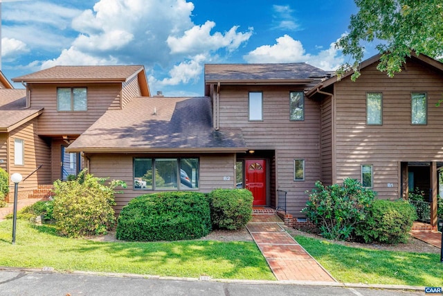 view of front facade featuring a front yard and roof with shingles