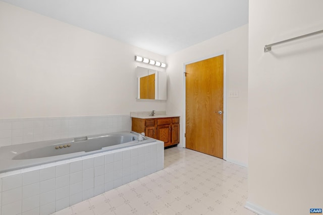 bathroom with baseboards, a garden tub, vanity, and tile patterned floors