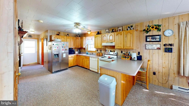 kitchen with a peninsula, white appliances, a wealth of natural light, and under cabinet range hood