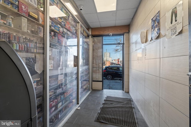 interior space featuring dark tile patterned flooring and a paneled ceiling