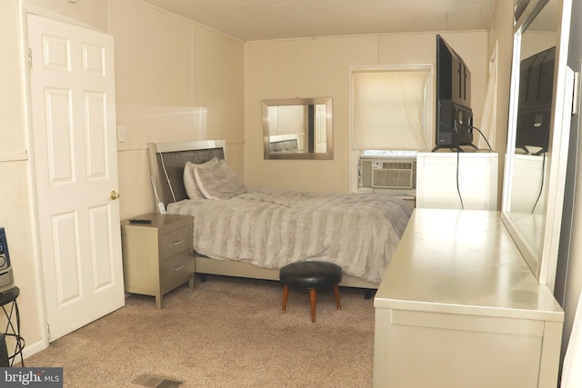 bedroom with cooling unit and light colored carpet