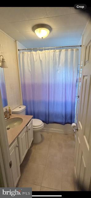 full bathroom featuring vanity, toilet, shower / tub combo with curtain, and tile patterned floors