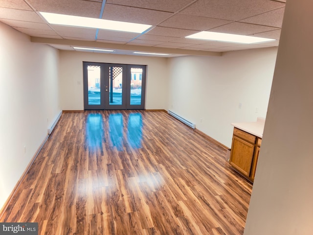 unfurnished room with dark hardwood / wood-style floors and a baseboard heating unit