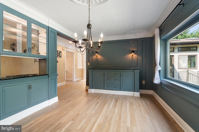 unfurnished dining area with ornamental molding, light hardwood / wood-style floors, and a chandelier