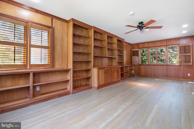 spare room featuring ceiling fan, wood walls, plenty of natural light, and light hardwood / wood-style floors