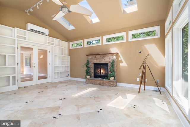 unfurnished living room featuring ceiling fan, a skylight, french doors, a fireplace, and a wall mounted air conditioner