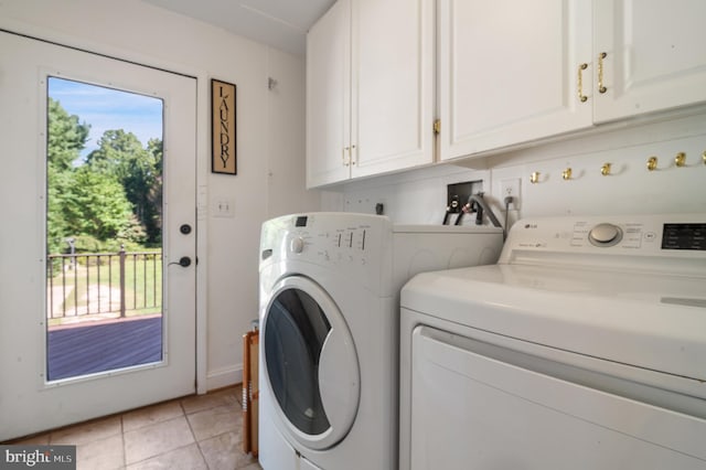 washroom featuring cabinets, light tile patterned flooring, and washer and clothes dryer