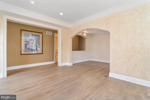 empty room with light wood-type flooring and crown molding