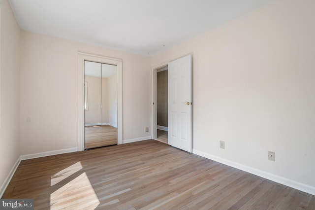 unfurnished bedroom with light hardwood / wood-style flooring and a closet