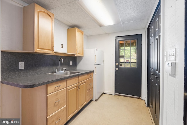 kitchen featuring decorative backsplash, white refrigerator, light brown cabinets, a paneled ceiling, and sink