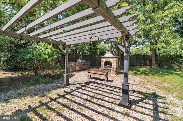 view of yard with a pergola and an outdoor stone fireplace