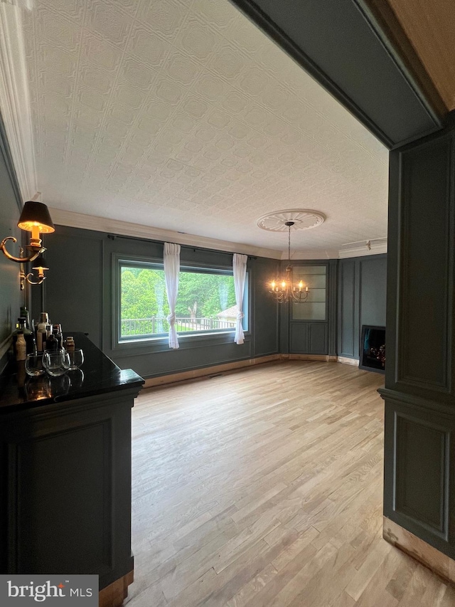 interior space featuring light wood-type flooring, a textured ceiling, and a chandelier