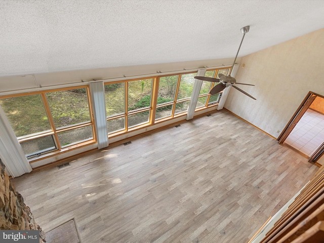 unfurnished living room featuring a textured ceiling, hardwood / wood-style floors, and ceiling fan