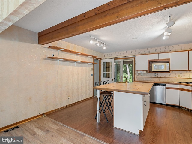 kitchen featuring a center island, white cabinetry, butcher block countertops, wood-type flooring, and stainless steel dishwasher