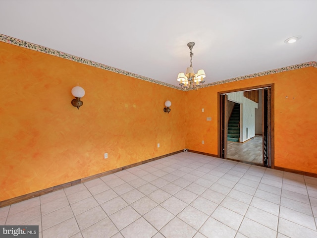 empty room featuring a chandelier and light tile patterned flooring