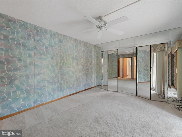 unfurnished bedroom with a textured ceiling, carpet flooring, ceiling fan, and a closet