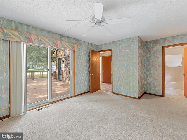 carpeted empty room featuring a textured ceiling and ceiling fan