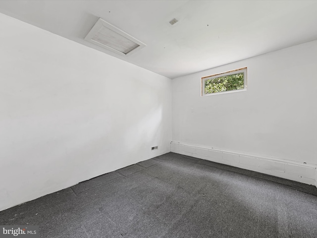 spare room featuring dark carpet