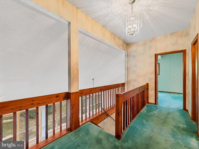 hall featuring an inviting chandelier and carpet