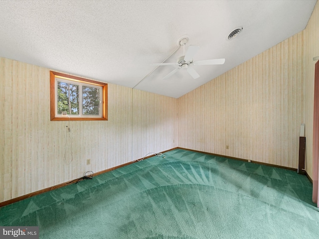 empty room featuring a textured ceiling, carpet flooring, and ceiling fan