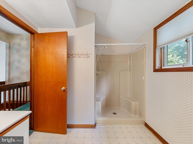 bathroom with a shower, lofted ceiling, a textured ceiling, and vanity