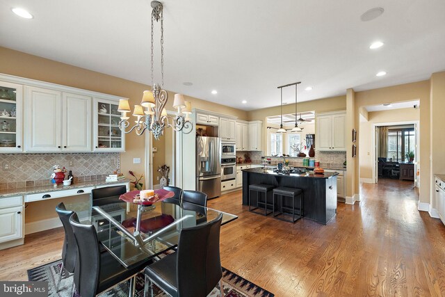 dining area featuring wood-type flooring and a chandelier