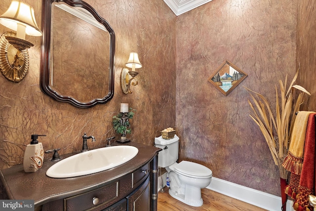 bathroom featuring crown molding, vanity, toilet, and hardwood / wood-style flooring