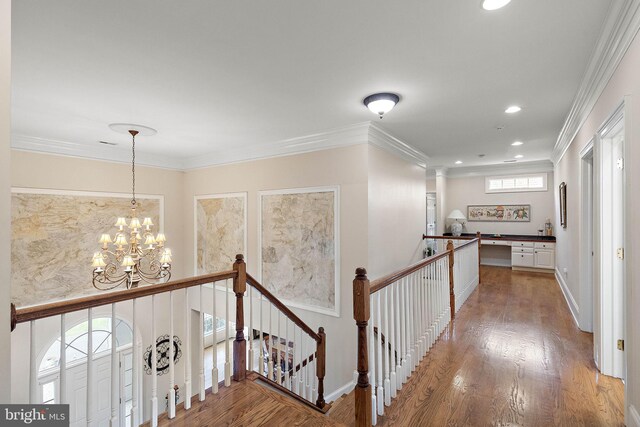 hallway with crown molding, plenty of natural light, hardwood / wood-style floors, and a notable chandelier