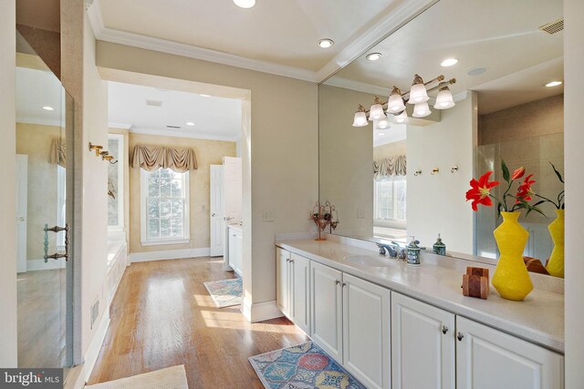 bathroom featuring ornamental molding, vanity, hardwood / wood-style floors, and a shower