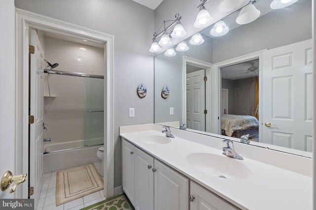 full bathroom with tile patterned flooring, tiled shower / bath, toilet, and vanity