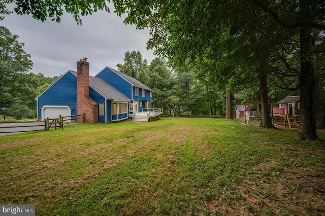 view of yard featuring a garage and a wooden deck