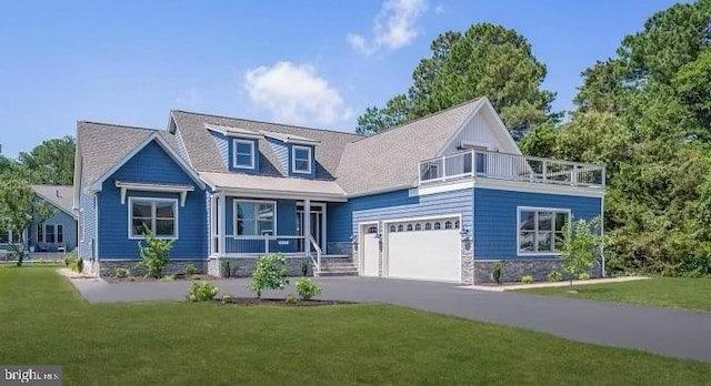 exterior space featuring a porch, a garage, and a front lawn