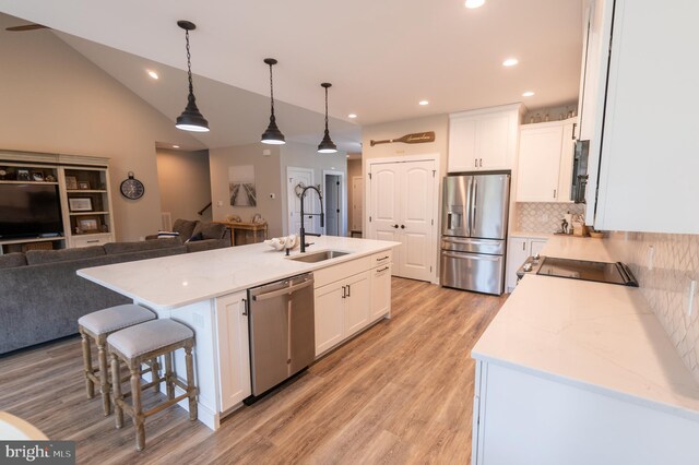 kitchen with a kitchen island with sink, stainless steel appliances, and sink