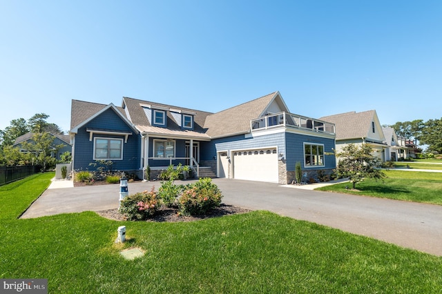 view of front of house featuring driveway, stone siding, a porch, and a front lawn