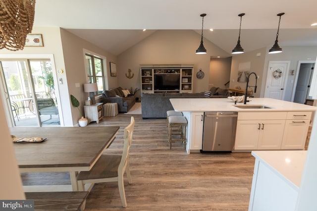 kitchen featuring white cabinetry, light hardwood / wood-style flooring, an island with sink, sink, and stainless steel dishwasher