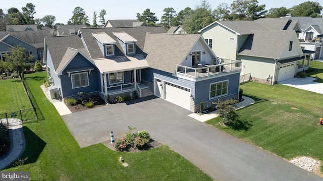 view of front facade with a balcony, a front yard, and a garage