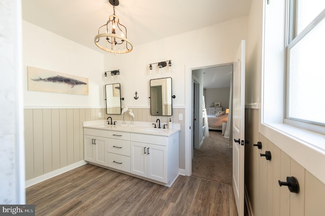 bathroom featuring wood-type flooring, wooden walls, a chandelier, and vanity