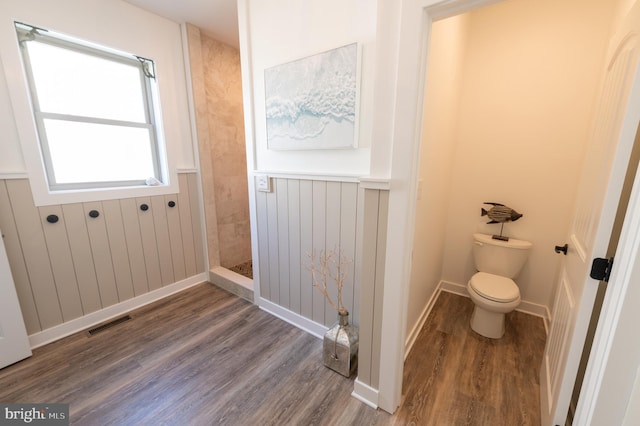 bathroom featuring toilet, hardwood / wood-style flooring, and walk in shower