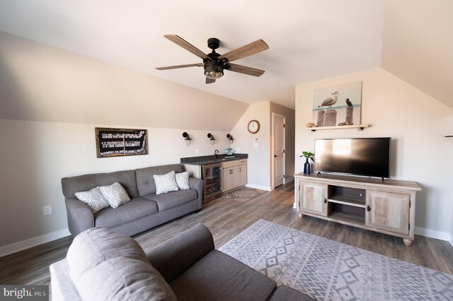 living room with dark wood-type flooring, vaulted ceiling, beverage cooler, and ceiling fan