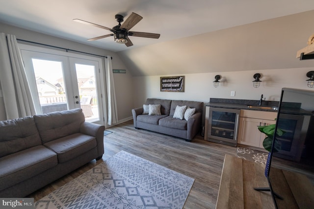 living room featuring wine cooler, wet bar, ceiling fan, lofted ceiling, and light hardwood / wood-style floors