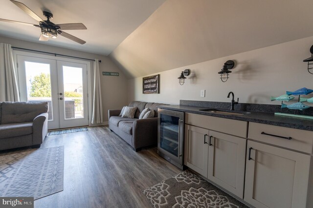 living room with beverage cooler, french doors, sink, dark wood-type flooring, and vaulted ceiling