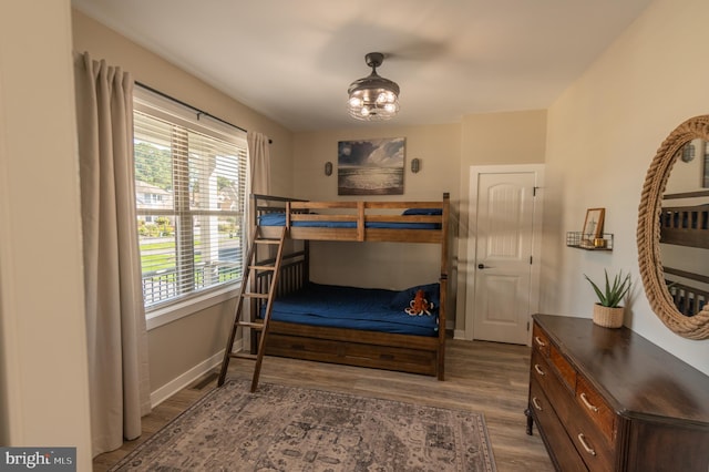 bedroom featuring an inviting chandelier and wood-type flooring