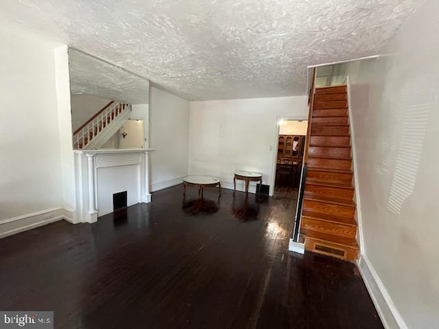 living room with dark hardwood / wood-style flooring and a textured ceiling