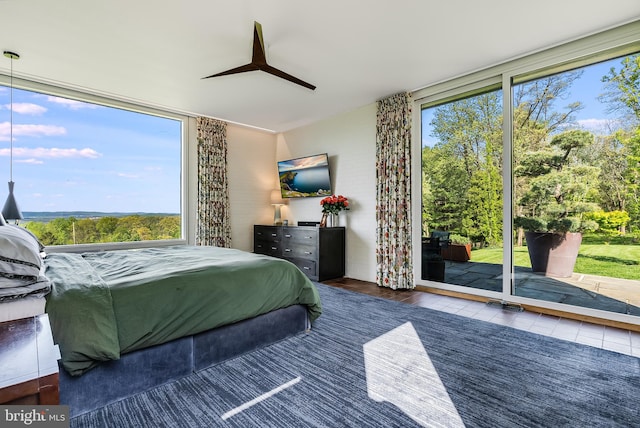 tiled bedroom featuring ceiling fan and access to exterior